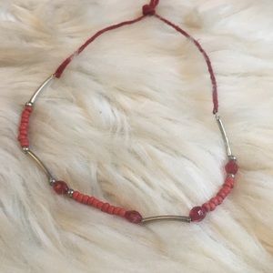 Red and silver choker necklace on rawhide
